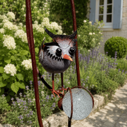 Babyeule und bernsteinfarbene Glaskugel am Garten-Mobile