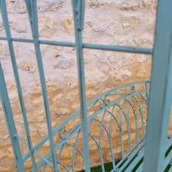 Bequeme Gartenbank aus patiniertem Schmiedeeisen in antikem Grün