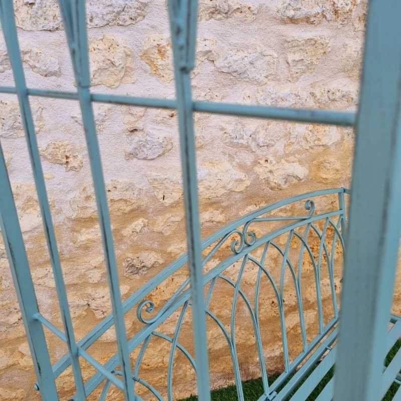 Bequeme Gartenbank aus patiniertem Schmiedeeisen in antikem Grün