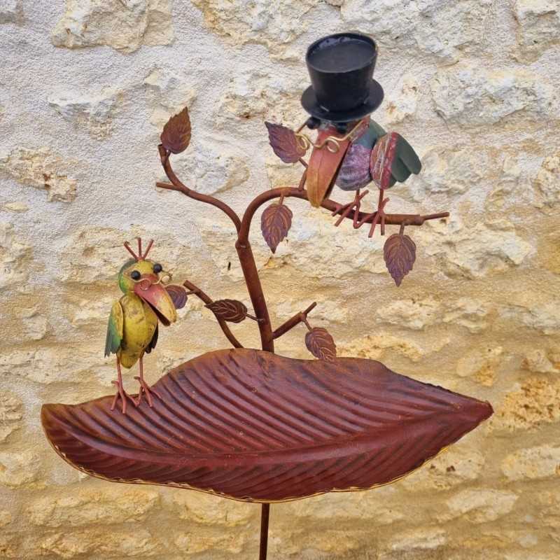 Bunter Metallvogel mit schwarzem Zylinder auf einem Zweig