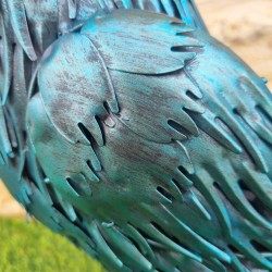 Detailansicht des türkisblauen Körpers mit strukturierten Metallfedern