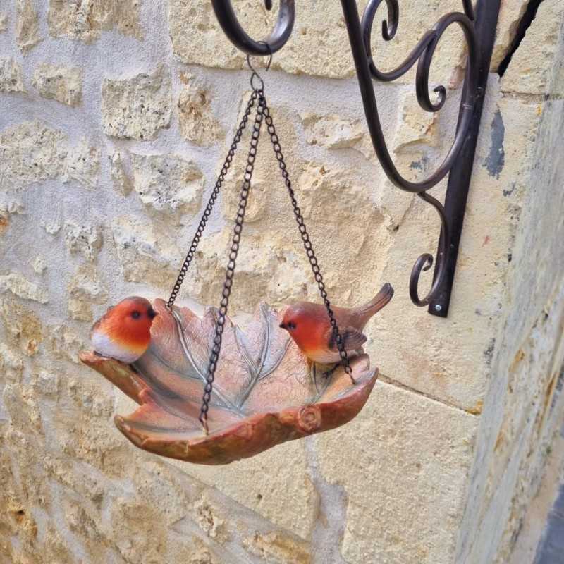 Vogelfutterstelle mit Rotkehlchen an einer Wandhalterung