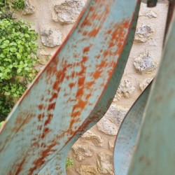 Detail der grün-goldenen Patina auf den gebogenen Metallflügeln