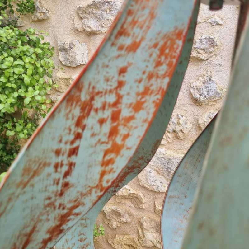 Detail der grün-goldenen Patina auf den gebogenen Metallflügeln