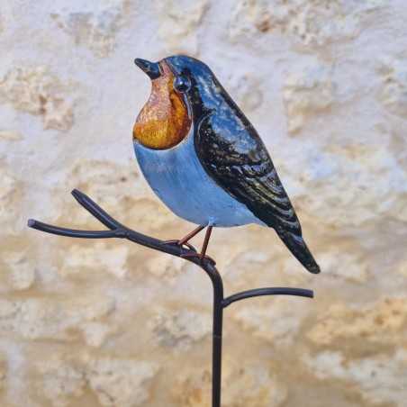Dekorativer Vogel auf orangefarbenem Spieß