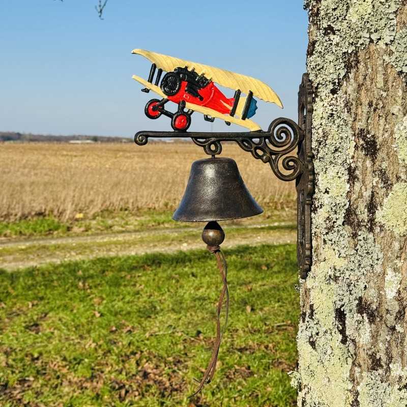 Türglocke mit Doppeldecker an einer Steinwand neben einer Holztür