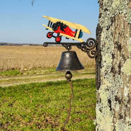 Gusseisen-Glocke an der Wand montiert mit einem bunten Doppeldeckerflugzeug