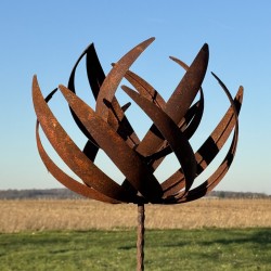 Vollansicht der dekorativen Gartenwindmühle aus rostigem Metall unter klarem Himmel