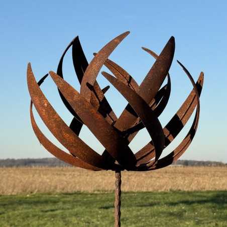 Vollansicht der dekorativen Gartenwindmühle aus rostigem Metall unter klarem Himmel