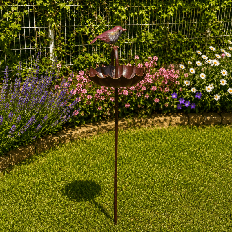 Vogeltränke und Futterstelle im Blumenbeet