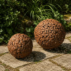Rostbraune Gartenkugel aus Metall mit ausgeschnittenen Blumenmotiven für Beet und Terrasse