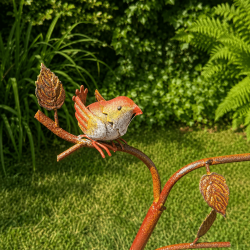 Dekorative Metallvögel auf Zweigen mit Blätterdekor