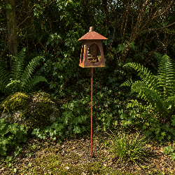 Vogelfutterstelle in Laternenform auf hohem Erdspieß im Garten