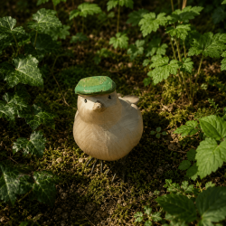 Vogelfigur aus Kunstharz mit grüner Baskenmütze